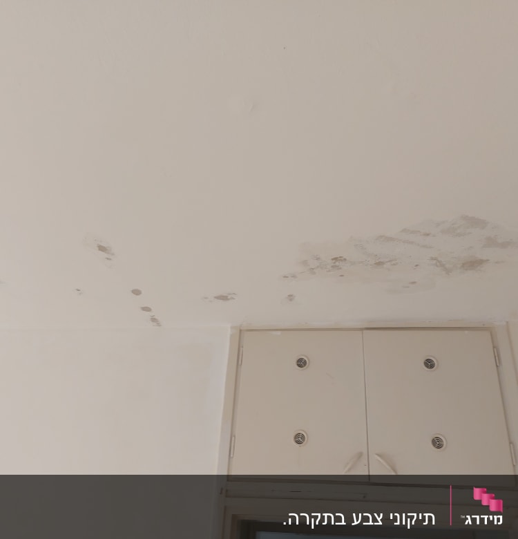 כתמי רטיבות ותיקוני צבע על תקרה לבנה